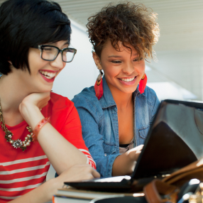 Two students smiling on laptop 