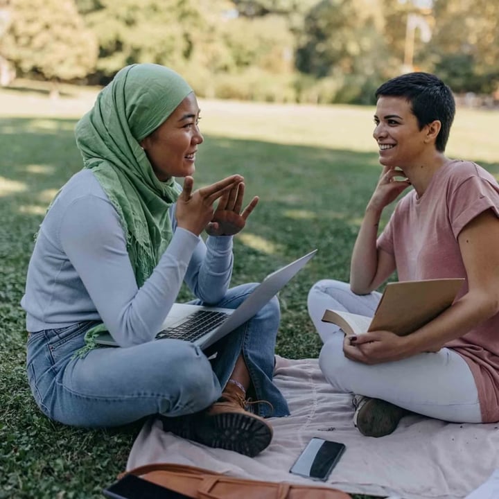 Friends talking in park on blanket