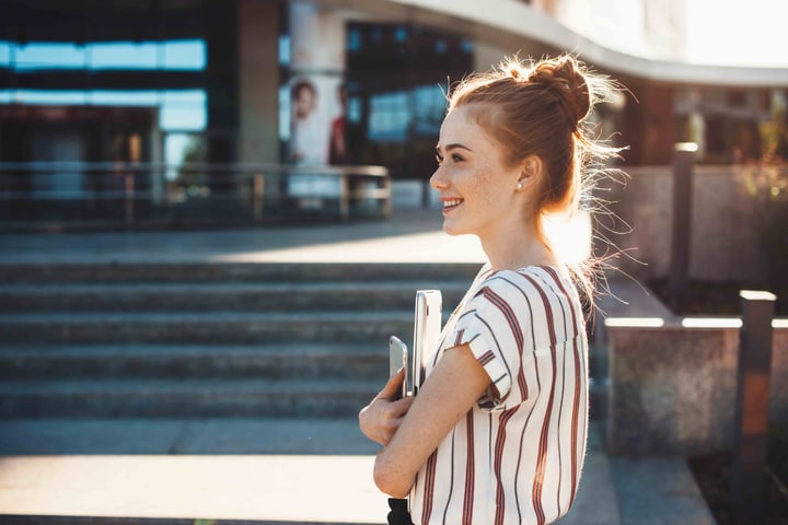 Person walking on sunny day with books