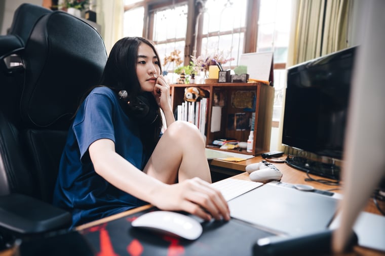 Student sitting at desk doing homework on laptop