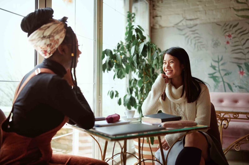 Two friends sitting at a table talking