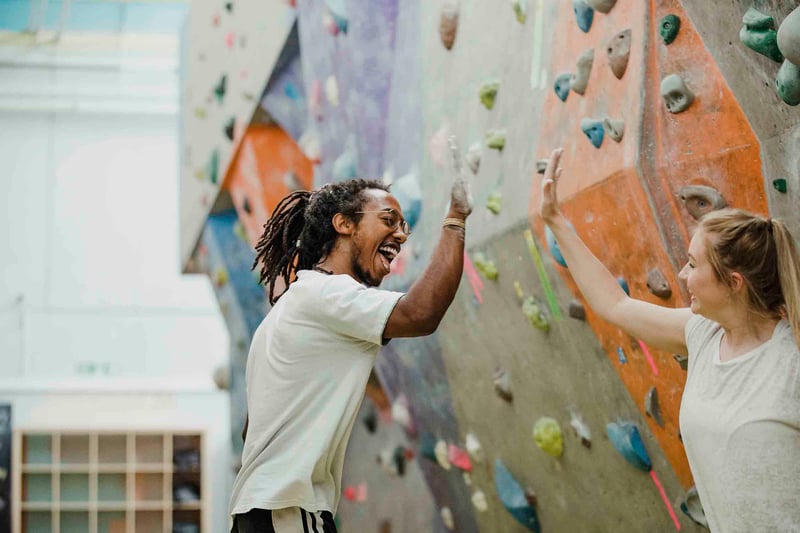 People high fiving at a rock climbing gym