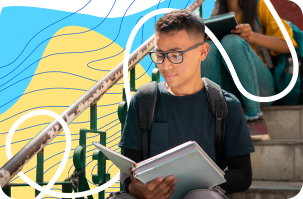 Student sitting on steps reading a book