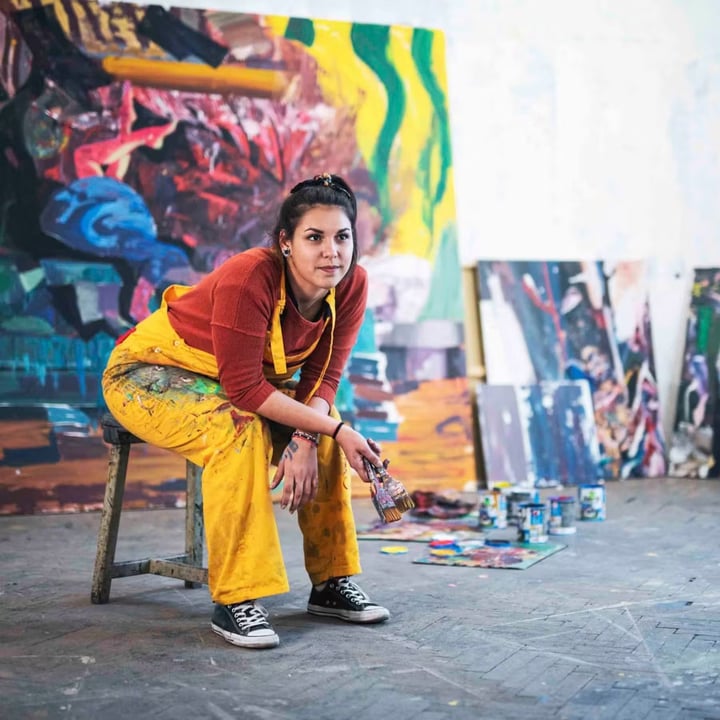 Girls sitting on chair in front of painting